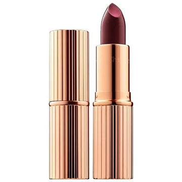 Model applying lipstick for a luminous, full-coverage lip look