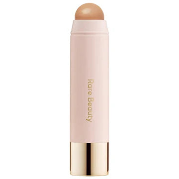 Hand blending cream bronzer with a brush for a soft, sculpted effect