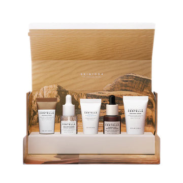 Skincare product set with bottles and cream in a wooden display box, featuring the brand 'Skin1004'.