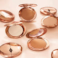 Pressed setting powder in gold compact placed on a clean vanity surface

