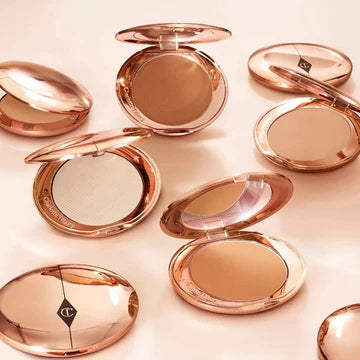 Pressed setting powder in gold compact placed on a clean vanity surface

