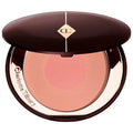 Model applying blush to cheekbones using outer shade for sculpting

