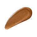 Model applying contour to cheekbone with cushion tip, mid-blend for a natural sculpt

