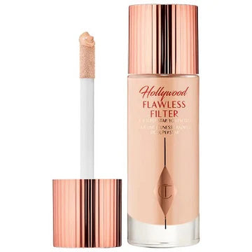 Model applying glow booster to cheekbones for radiant finish

