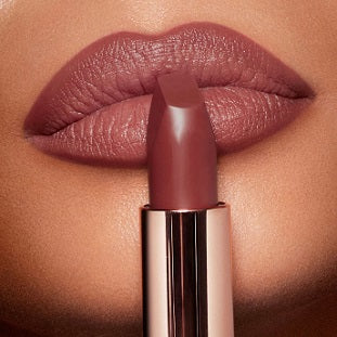 Close-up of lips wearing the matte lipstick in a warm nude shade, showing smooth finish

