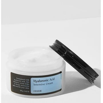 Close-up of COSRX Hyaluronic Acid Intensive Cream jar (100g) showing the brand logo and product name, a deeply hydrating moisturizer for dry and sensitive skin types