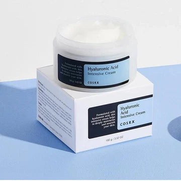 Close-up of COSRX Hyaluronic Acid Intensive Cream jar (100g) showing the brand logo and product name, a deeply hydrating moisturizer for dry and sensitive skin types