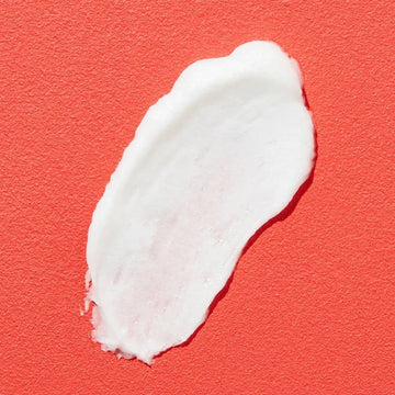 Close-up of COSRX Salicylic Acid Daily Gentle Cleanser's clear gel formula being dispensed from its white pump bottle, showing its lightweight, lathering texture ideal for acne-prone skin