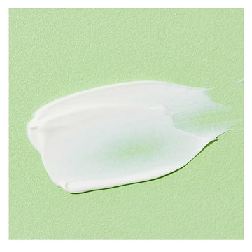 Close-up swatch of COSRX Aloe Soothing Sun Cream showing its creamy, lightweight texture on a green background.
