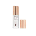 Charlotte Tilbury setting spray bottle placed elegantly beside makeup brushes

