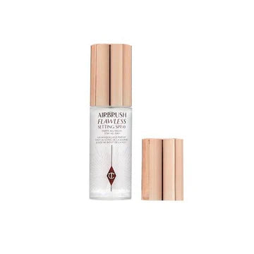 Charlotte Tilbury setting spray bottle placed elegantly beside makeup brushes

