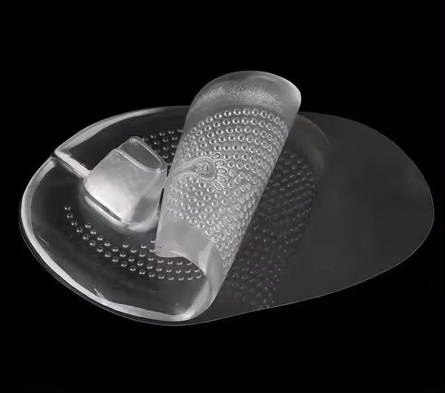 Transparent silicone foot pad with textured surface on a black background
