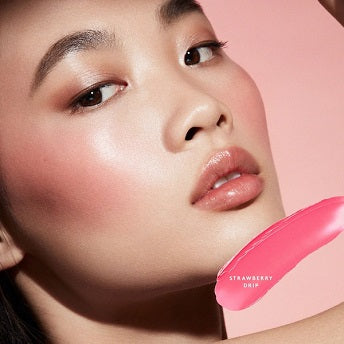 Close-up of a model applying light cream blush on cheeks for a natural glow.

