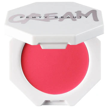 Close-up of a model applying light cream blush on cheeks for a natural glow.

