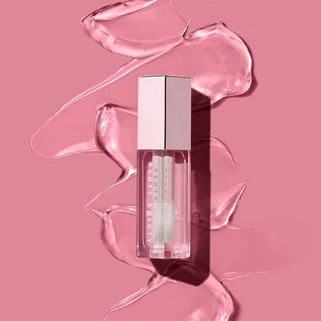 Close-up of a lip gloss applicator with a glossy shine on the wand.

