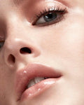 Swatches of multiple lip gloss shades on different skin tones