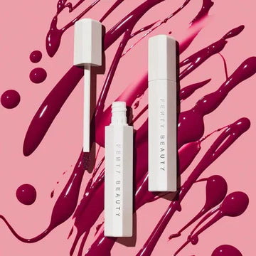 Close-up of glossy lip stain tube with a vibrant color swatch, highlighting its hydrating formula.

