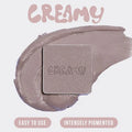 Close-up of Huda Beauty Creamy Obsessions Greige palette showing intensely pigmented cream eyeshadows with 'One Palette, Endless Looks' tagline visible