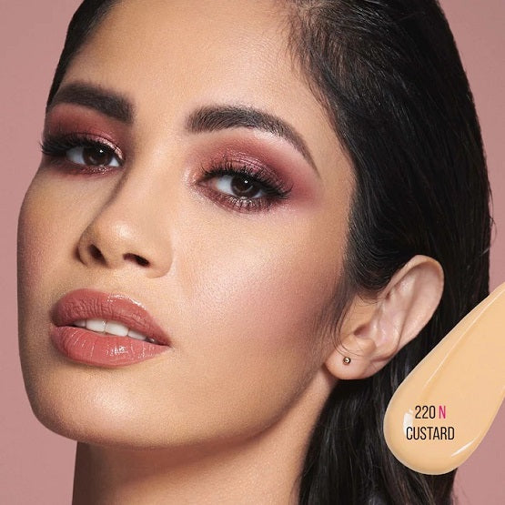 Model wearing Huda Beauty #FauxFilter Luminous Matte Foundation in shade 220N Custard, showcasing smooth, flawless full coverage with a matte finish.