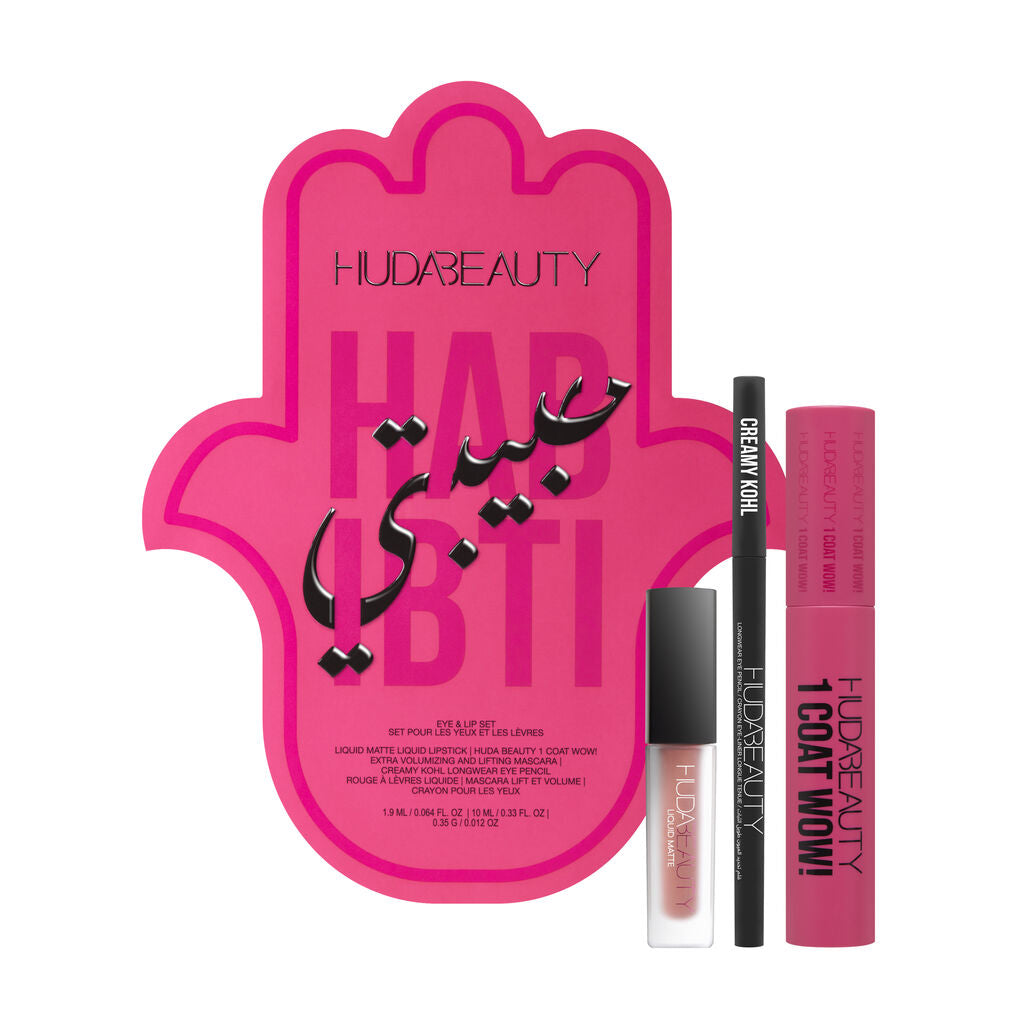 Huda Beauty Habibti Eye & Lip Set featuring the 1 Coat WOW! Volumizing Mascara, Creamy Kohl eyeliner, and Liquid Matte Lipstick in a luxurious travel-friendly kit. The packaging displays the brand's signature gold-and-pink aesthetic with product names in English and French