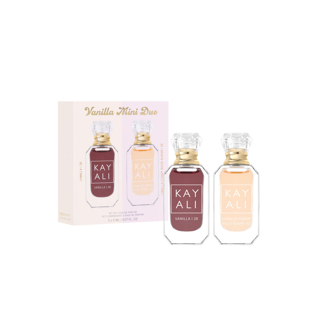 HUDA BEAUTY Kayali Mini Vanilla Perfume Duo Set featuring two small bottles of vanilla perfume with gold caps. The text 'VANILLA 28' and 'VANILLA 128' is visible on the bottles, along with 'KAYALI' branding. Fragrance notes or descriptions may include 'STOXYEZ LOUIS BARBIN' and 'SCONNECTUM Z EMAY DE PARFUM