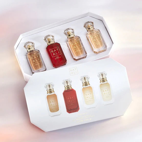 Four KAYALI 10ml mini perfumes in gold-capped bottles (Vanilla 28, Juicy Apple 01, White Flower 57, Amber 23) displayed with minimalist brandingFour KAYALI 10ml mini perfumes in gold-capped bottles (Vanilla 28, Juicy Apple 01, White Flower 57, Amber 23) displayed with minimalist branding