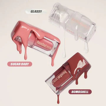 Top view of Huda Beauty Mini Glossiest Lip Gloss Set showing three mini tubes: Glassy, Sugar Baby, and Bombshell shades