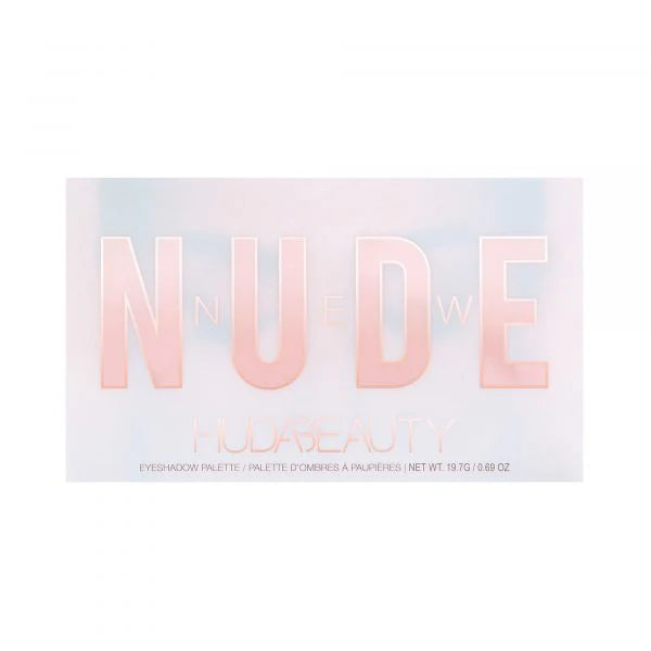HUDA BEAUTY The New Nude Eyeshadow Palette showing nine shades including DARE (rich plum), OPINE (soft mauve), PLAY (champagne shimmer), FANTASY (peachy nude), LOVE BITE (deep berry), SPARKED (golden bronze), LACE (pale ivory), DANDERAM (warm terracotta), and TOALE (cool taupe) in rectangular pans with shade names visible beneath each
