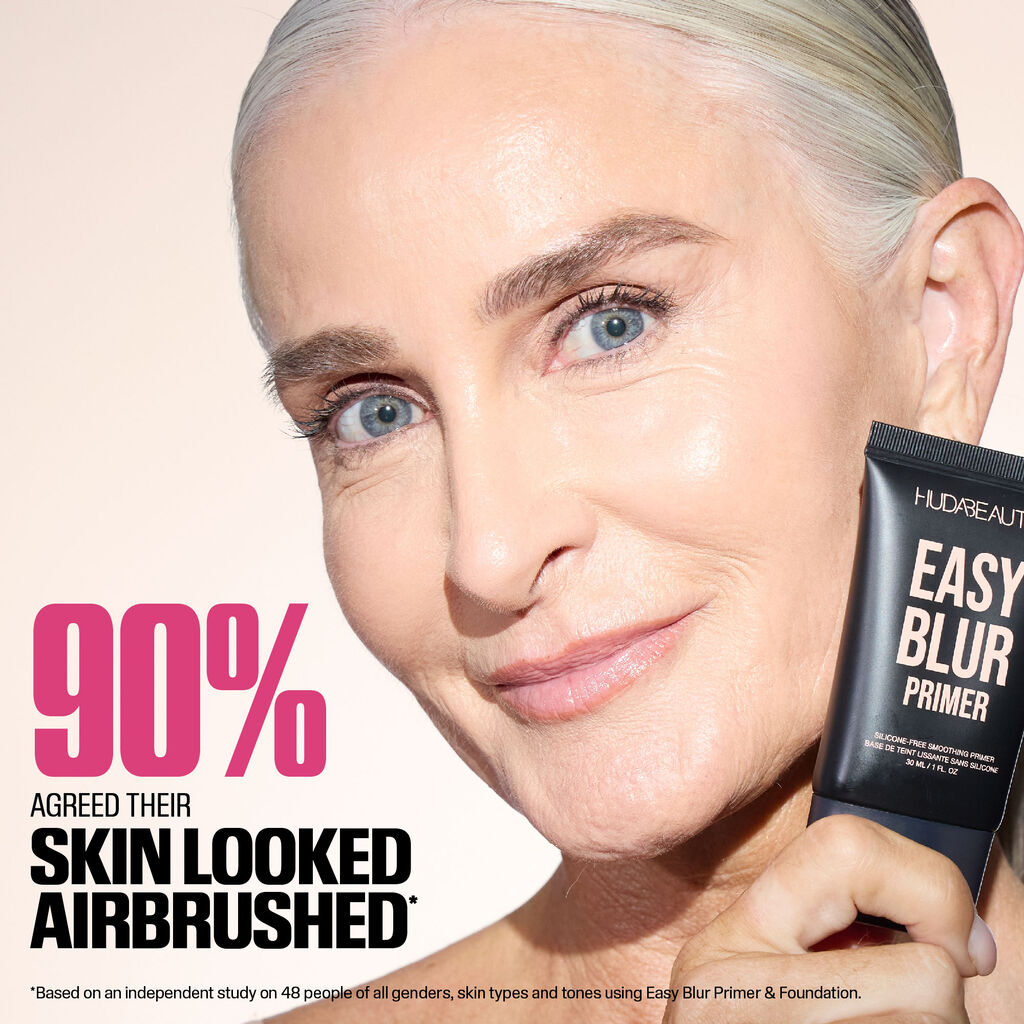 A clean product shot of Huda Beauty’s Easy Blur Primer in its 30ml bottle. The silicone-free smoothing primer is showcased with elegant branding, including the tagline 'Silicone-Free Smoothing Primer' and its French translation. The minimalist presentation highlights the luxurious packaging, emphasizing its lightweight, pore-blurring formula for a flawless makeup base