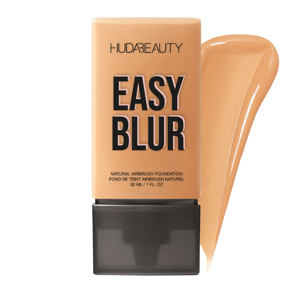 Product image of Huda Beauty Easy Blur Foundation in the shade “Macchiato 400G.” The sleek rectangular beige tube with black cap features bold black typography, and a smooth foundation swatch is displayed elegantly alongside the packaging. The product is labeled as a natural airbrush foundation in a 30ML (1 FL. OZ) size.