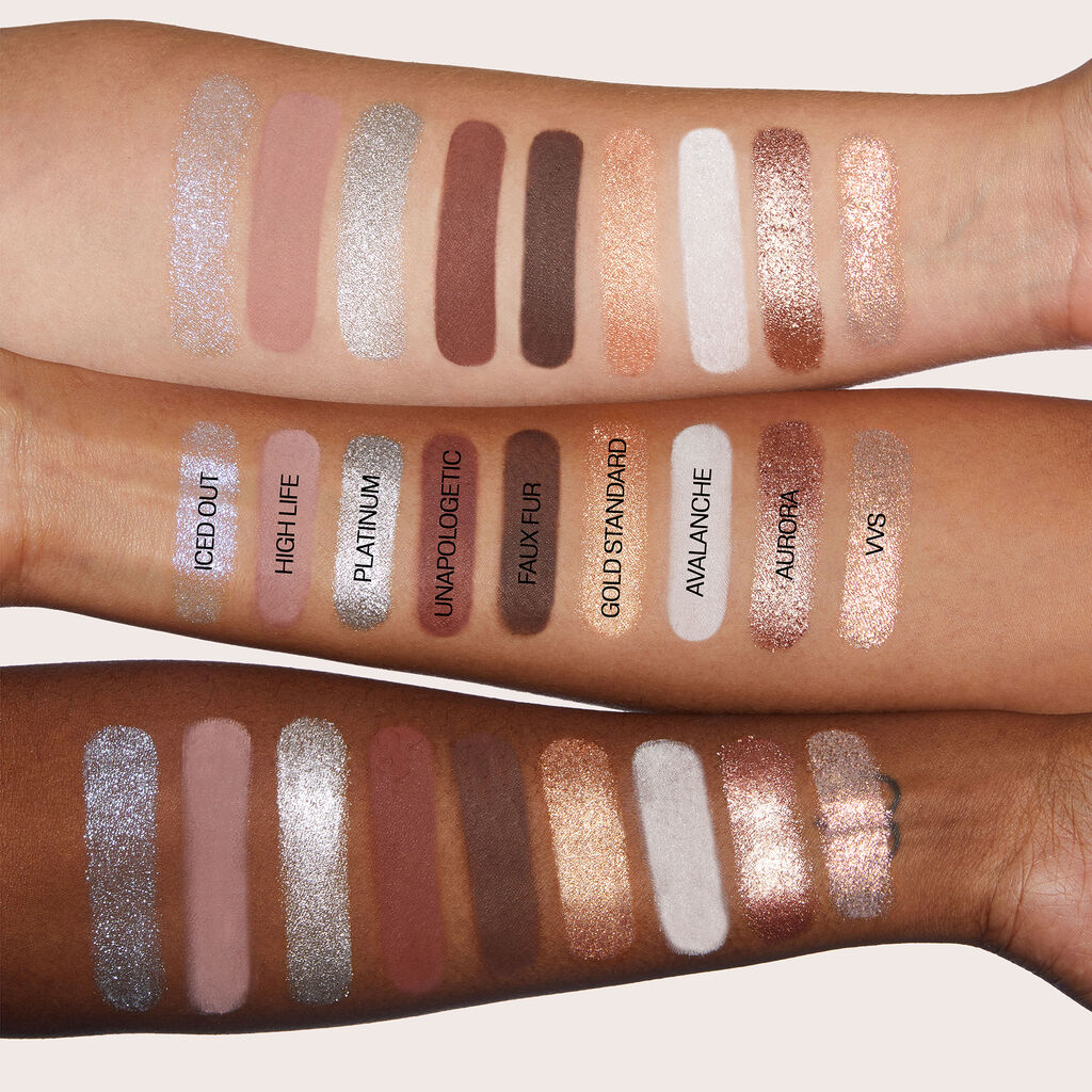Arm swatches of the Huda Beauty Icy Nude eyeshadow palette on three different skin tones, showcasing shimmery, matte, and metallic shades including Iced Out, High Life, Platinum, Unapologetic, Faux Fur, Gold Standard, Avalanche, Aurora, and VVS
