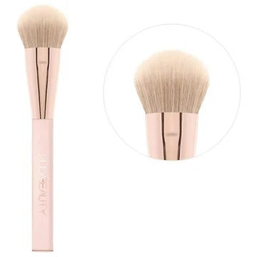 HUDA BEAUTY angled synthetic blush brush with tri-length fibers for diffused application of cream, gel or powder products, showing the antibacterial bristles and ergonomic handle