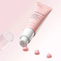 Pink skincare product with white cap on a light pink background
