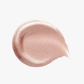 Flat lay of the luminizer next to blush and makeup brushes on a vanity

