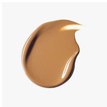 Model applying tinted moisturizer using fingers for a quick, natural look.

