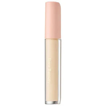 Model applying brightener under the eyes for a fresh, radiant finish.

