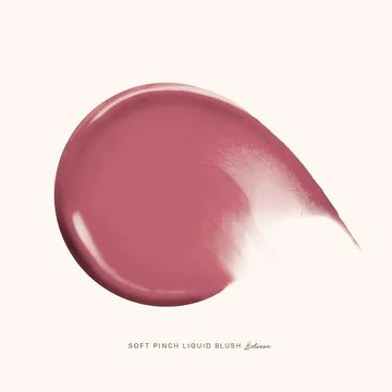Liquid blush applicator dispensing a drop of product onto a makeup brush with a soft background.

