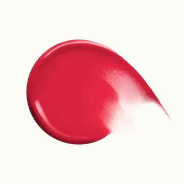Product tube with applicator wand placed next to blush droplets

