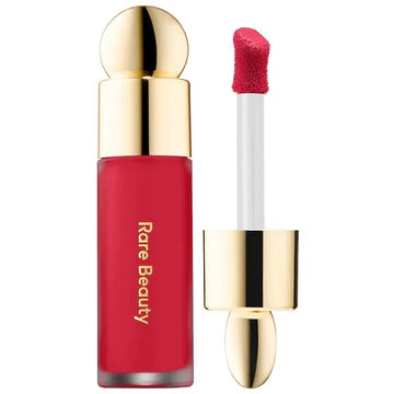 Product tube with applicator wand placed next to blush droplets

