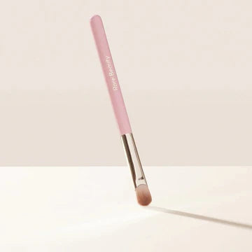Makeup artist applying eyeshadow using the brush for smooth blending across the eyelid.

