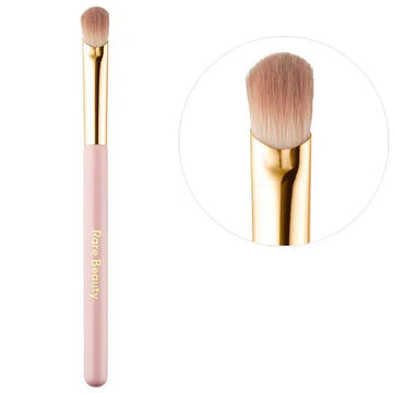 Makeup artist applying eyeshadow using the brush for smooth blending across the eyelid.

