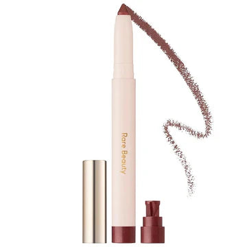 Model applying eyeshadow stick for soft smoky eye makeup look

