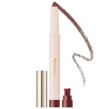 Model applying eyeshadow stick for soft smoky eye makeup look


