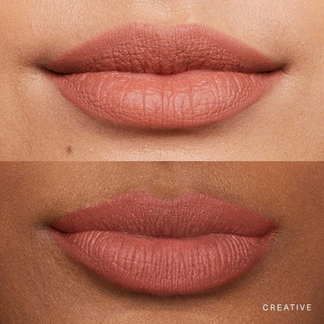 Model applying soft matte lipstick with a smooth, even finish on her lips.

