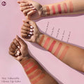 Glossy swatches of lip gloss shades on skin tones ranging from light to deep.

