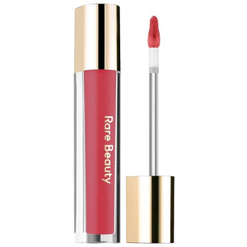 Model applying lip gloss, showcasing a smooth and shiny finish.

