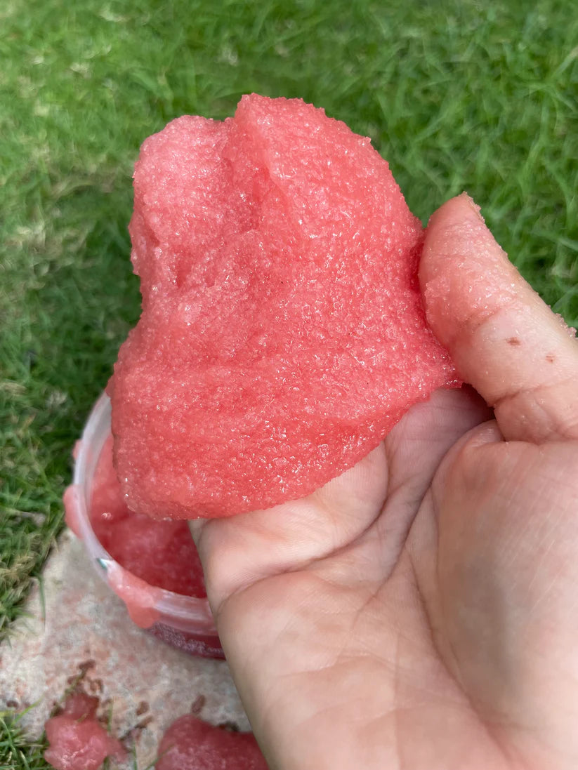 Close-up of the raspberry scrub texture on a wooden spatula, highlighting its smooth and rich consistency.
