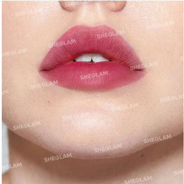 bottle of SHEGLAM For The Flush Lip & Cheek Tint in "Strawberry" is shown next to its cap with an applicator wand extended, displaying a vibrant red tint. The bottle's label includes "SHEGLAM" and "Strawberry" with a graphic of two strawberries