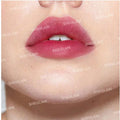 person's lips wearing a red-pink lip tint that is slightly diffused at the edges, creating a soft, gradient effect. The 