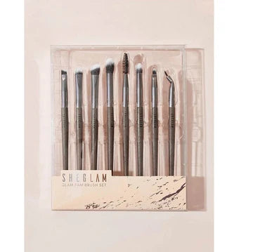 SHEGLAM Glam Fam 8-piece brush kit displayed with branded text 'SHEBLAN' and 'SHAN AND BRIAN EO.' The set includes a variety of face and eye brushes with sleek black handles, designed for professional-grade makeup application